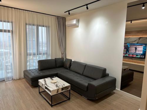 a living room with a black couch and a table at Belgrade Waterfront Sole in Sajmište