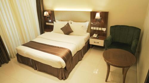 Habitación de hotel con cama y silla en KIGALI DELIGHT HOTEL &APARTMENTS en Kigali