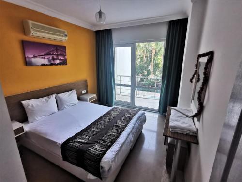 a hotel room with a bed and a window at Maya Apart Antalya in Antalya
