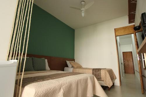 um quarto com 2 camas e uma parede verde em Sunset Rio no Rio de Janeiro