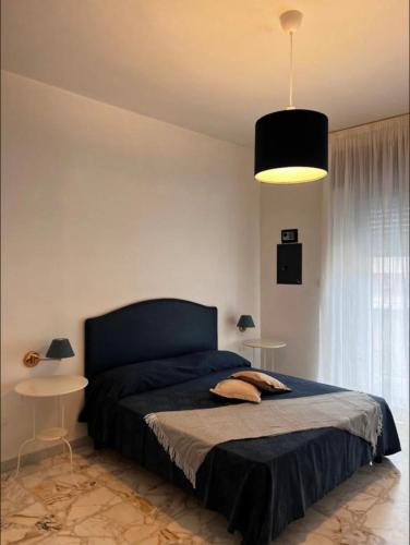 una camera da letto con un letto con copriletto nero e una lampada di La Casa di Giovanni - Apartment in the center of Maiori a Maiori