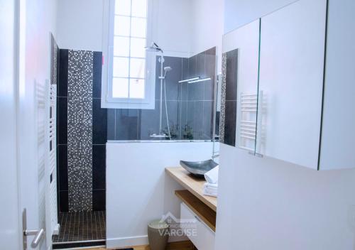 une salle de bain blanche avec une douche et un lavabo dans l'établissement Grand Standing Hyères T3 - Vue mer - Piscine - Tennis, à Hyères