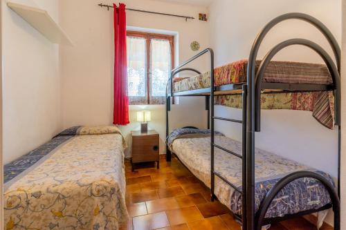1 Schlafzimmer mit 2 Etagenbetten und einem Fenster in der Unterkunft Casa Valu in Bari Sardo