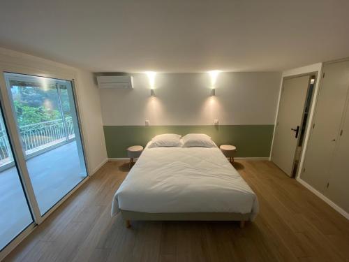 een slaapkamer met een bed in een kamer met een raam bij Sea and Sun in Saint-Raphaël