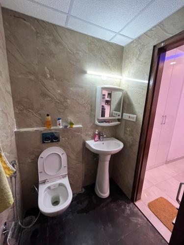 a bathroom with a toilet and a sink and a shower at Estates Model in Greater Noida
