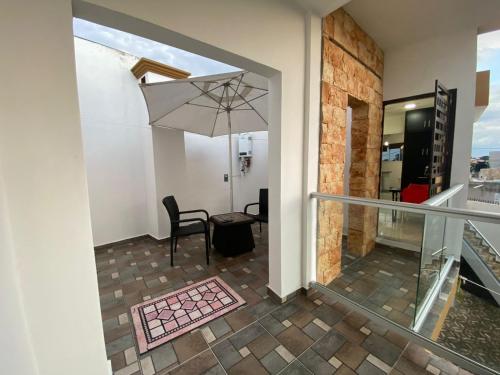 a dining room with a table and an umbrella at Un departamento a tu gusto in Valladolid