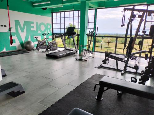 a gym with cardio equipment and a large window at Hotel Arbóreo Doradal in Doradal