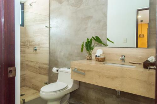 a bathroom with a toilet and a sink and a shower at Hotel Boutique Casa Xaan in Valladolid