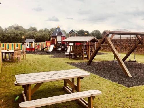 a park with a bench and a playground at Royal Ascot Holiday Home - 5 Star Country Park - Bar - Restaurant - Fishing Lakes - Ice Cream Parlour - FREE Parking in Scunthorpe