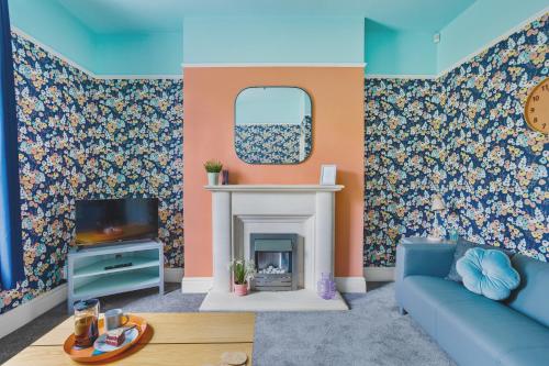 a living room with a blue couch and a fireplace at Harbour Court - Free Parking - tucked away on the Barbican - by Ocean City Retreats in Plymouth