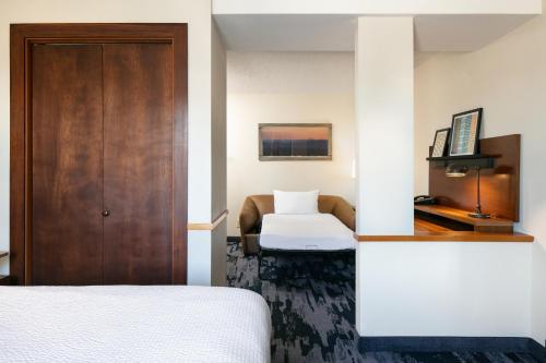 a hotel room with a bed and a door at Fairfield Inn & Suites by Marriott Tulsa Central in Tulsa