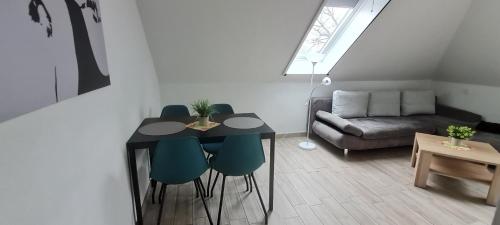 een woonkamer met een tafel en stoelen en een bank bij Spreewälder Ferienpension in Lübben