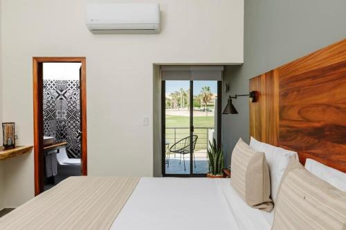 1 dormitorio con 1 cama grande y puerta corredera de cristal en 2 Amazing Suite King Rooms in Exclusive Boutique Hotel, en San José del Cabo