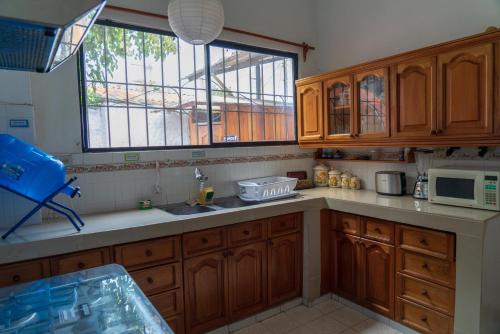 a kitchen with wooden cabinets and a sink and a window at Mare Mio in Puerto Baquerizo Moreno