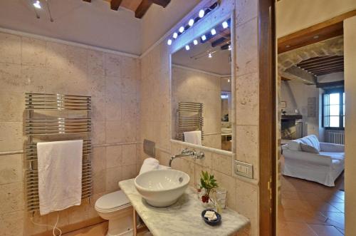 ein Badezimmer mit einem Waschbecken und einem großen Spiegel in der Unterkunft La Torre Vecchia in Castelnuovo Berardenga