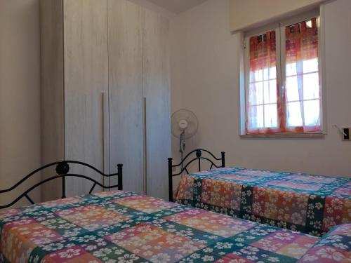 a bedroom with two beds and two windows at La Villetta in Cutrofiano