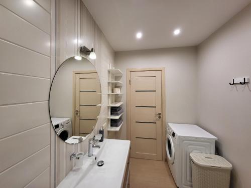 a bathroom with a sink and a mirror at Tarp Pušų - Jaukūs apartamentai - 15 min iki jūros in Palanga