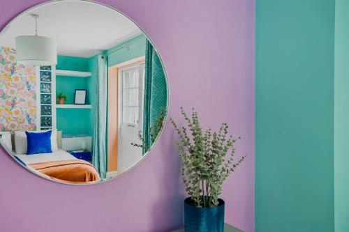 a mirror in a room with a bed and a vase with flowers at Harbour Court - Free Parking - tucked away on the Barbican - by Ocean City Retreats in Plymouth