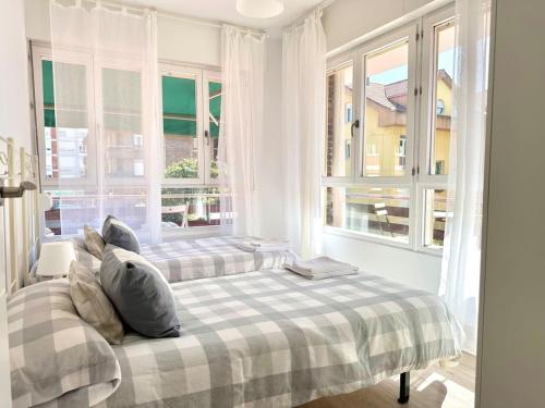 - 2 lits dans une chambre avec de grandes fenêtres dans l'établissement La Trainera - 30013, à Somo