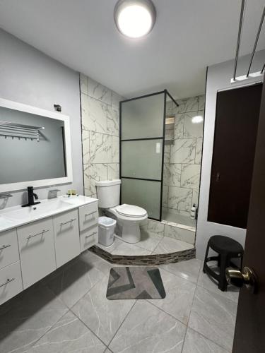 een badkamer met een toilet, een wastafel en een douche bij Spacious Unit with 5BR, 3BA Perfect for Big Groups, Near Ocean Park Beach in San Juan