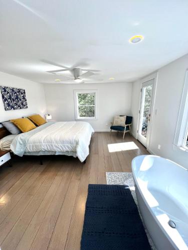 a bedroom with a bed and a bath tub at Waterfront Lakehouse Getaway in Clinton with HOT TUB in Clinton