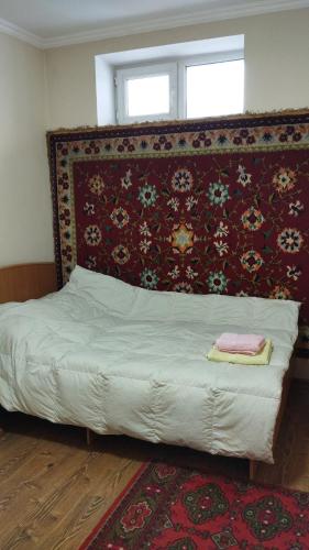 uma cama num quarto com uma parede vermelha em Гостевой дом em Prigorodnoye