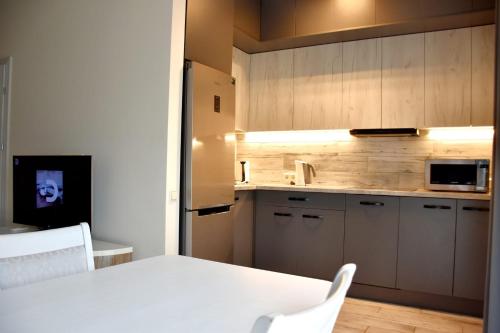 eine Küche mit einem weißen Tisch und einer Mikrowelle in der Unterkunft Green Acres Apartment in Palanga