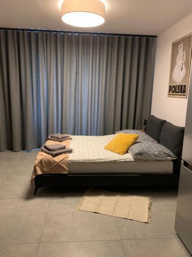 a bedroom with a bed in front of a curtain at Apartament w Dolinie Sanu 1 in Lesko