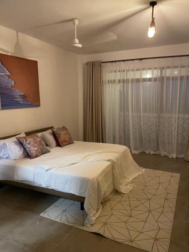 Sultan Palace Beach Home- Ahsan في مومباسا: غرفة نوم بسرير كبير مقابل نافذة