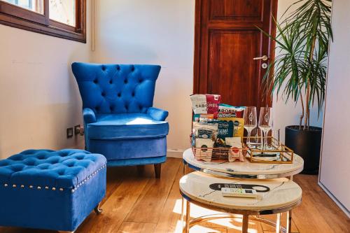 a living room with a blue chair and a table at Miravida Soho Hotel & Wine Bar in Buenos Aires