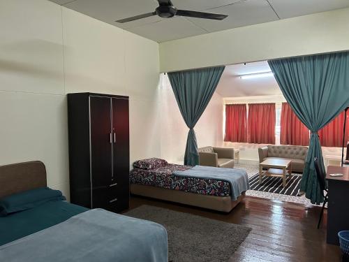 a bedroom with two beds and a living room at Minden Stay in Gelugor