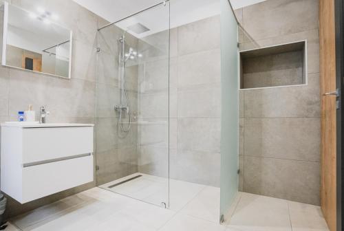 a bathroom with a shower with a glass door at Szent Miklós Apartman -Keco- in Szeged