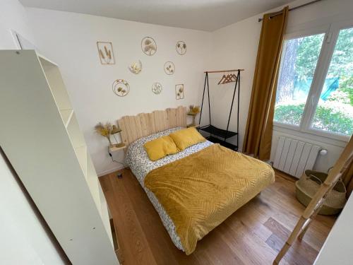 une chambre avec un lit avec une couverture jaune dans l'établissement Villa au calme dans un domaine boisé, à La Motte