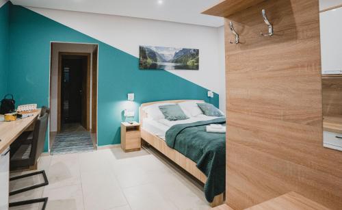 ein Schlafzimmer mit einem Bett und einer blauen Wand in der Unterkunft Szent Miklós Apartman -Keco- in Szeged