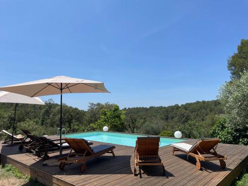 une terrasse avec des chaises et une piscine dans l'établissement Villa au calme dans un domaine boisé, à La Motte