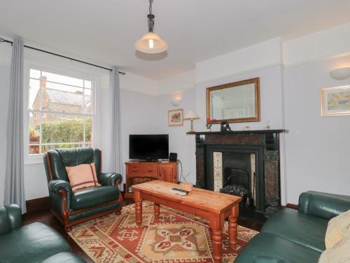 a living room with a couch and a fireplace at Cathay House in Cheddar
