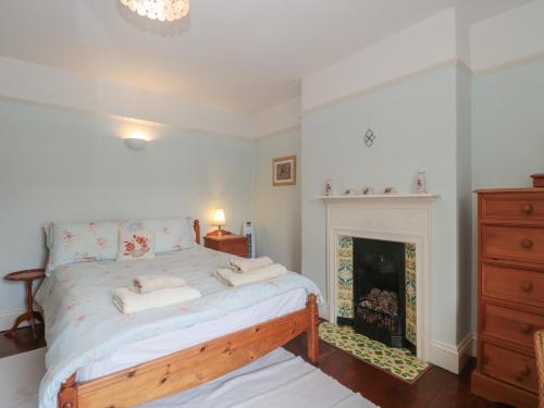 a bedroom with a bed and a fireplace at Cathay House in Cheddar