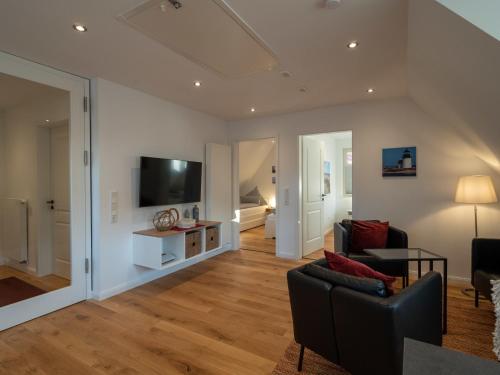 a living room with a couch and a tv at Noorderpad 5 Boven Deck in Spiekeroog