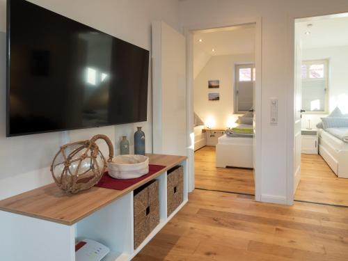 a living room with a large flat screen tv on a wall at Noorderpad 5 Boven Deck in Spiekeroog