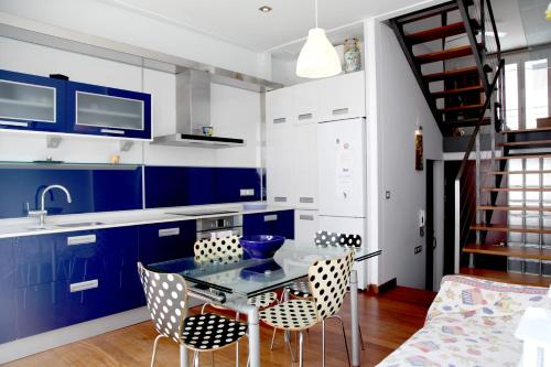 cocina con armarios azules, mesa y sillas en Casa Molinar, en Palma de Mallorca