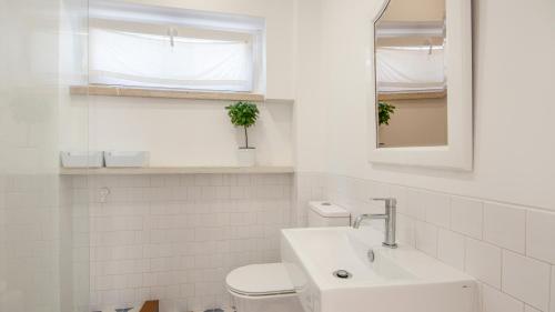 a white bathroom with a sink and a toilet at Ericeira 2BDR Coastal Escape by LovelyStay in Ericeira