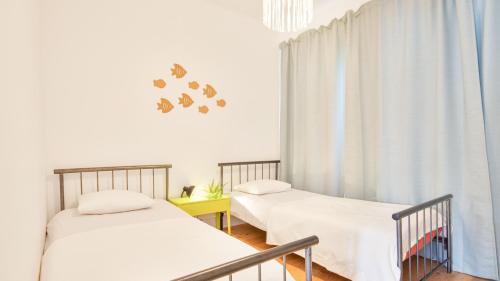 two beds in a room with white walls at Ericeira 2BDR Coastal Escape by LovelyStay in Ericeira