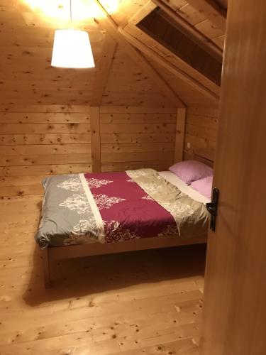 1 dormitorio con 1 cama en una cabaña de madera en Etno Domacinstvo Mitrovic 