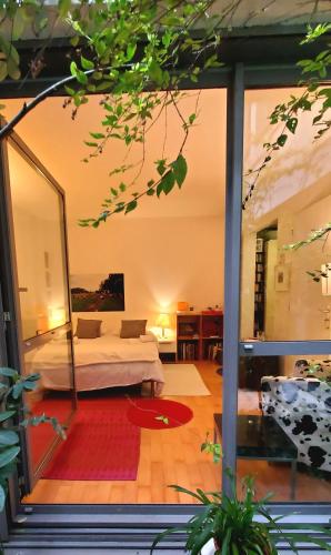 une chambre avec un lit et une grande fenêtre en verre dans l'établissement Une chambre à Paris 20eme avec un petit jardin, à Paris
