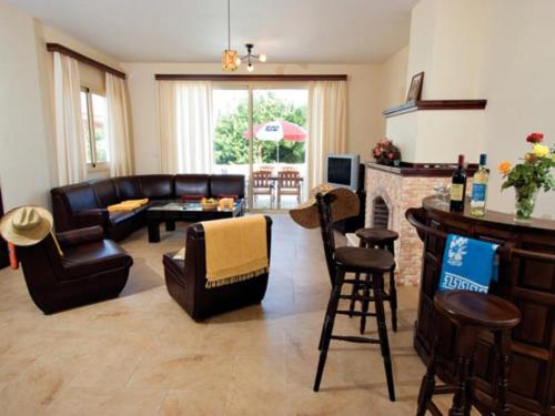 a living room with leather furniture and a fireplace at Jaime Villa Cyprus in Argaka