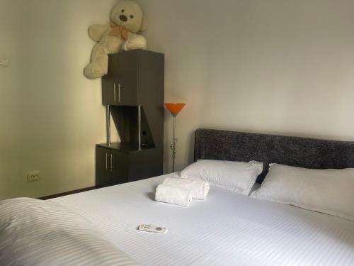 a bed with a stuffed teddy bear on top of it at Carlitos apt in Râmnicu Vâlcea