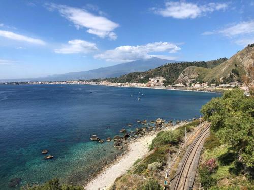 a view of a beach next to the water at Bluesky Apartment Naxos 3rd floor in Giardini Naxos
