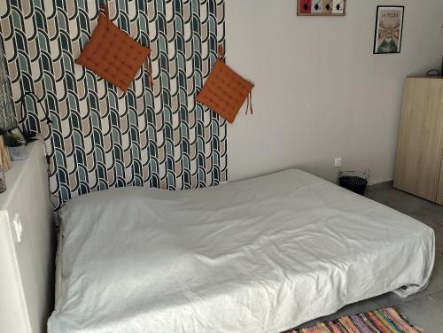 a bedroom with a bed with a black and white headboard at chambre avec un accès indépendant et salle de bain et toilette privatifs in Marquette-lès-Lille