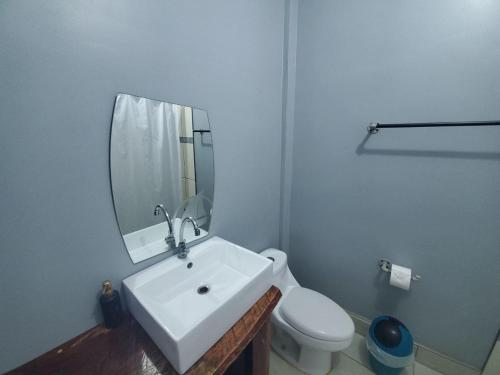 uma casa de banho com um lavatório, um WC e um espelho. em RodMar Hotel em El Cuco