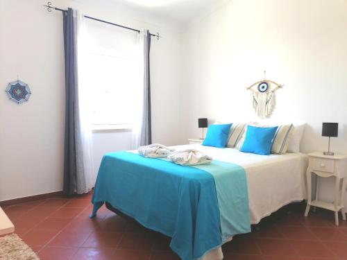 1 dormitorio con 1 cama con manta azul en Marreiro's house Algarve - Child friendy - Private Pool en Lagos